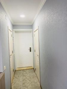 巴统sea view rooms in Batumi的走廊设有白色门,铺有瓷砖地板