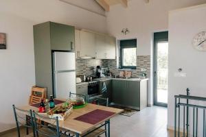 波帝卡Villa "Mons & Mare"的厨房配有桌椅和冰箱。