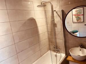 索波特Apartament Karlikowska z widokiem na morze的带淋浴、盥洗盆和镜子的浴室