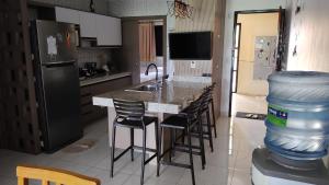 阿奎拉兹Aquaville Resort - Terreo Nascente - Beach Park的厨房配有带吧台和凳子的酒吧