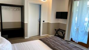 塞里亚泰Foresteria Green House的一间卧室设有一张床和一个滑动玻璃门