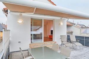 代德斯海姆Klimatisierte Wohnung mit großer Terrasse的阳台的天井配有玻璃桌椅