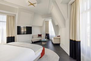巴黎Kimpton - St Honoré Paris, an IHG Hotel的一间卧室设有一张床和一间客厅。