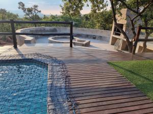 贝拉贝拉Livingstone Bush Lodge, Mabalingwe的通往带游泳池的木制斜坡