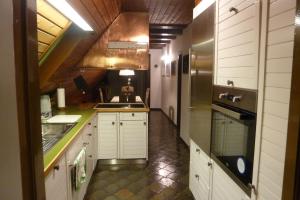 比德尔斯多夫Ferienwohnung Haus Anne的厨房配有白色橱柜和不锈钢冰箱
