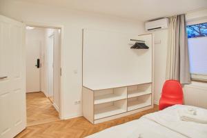 代德斯海姆Gemütliche Wohnung mit Balkon的一间卧室配有一张床和一张红色椅子