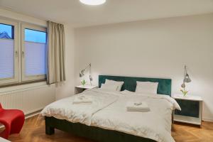 代德斯海姆Gemütliche Wohnung mit Balkon的一间卧室配有一张大床和一张红色椅子