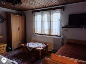 阿列谢尼Casa Sașilor的一间卧室配有一张床、一张桌子和一台电视