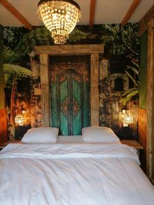 Oude PekelaVilla Le Jardin的一间卧室设有一张大床和绿门