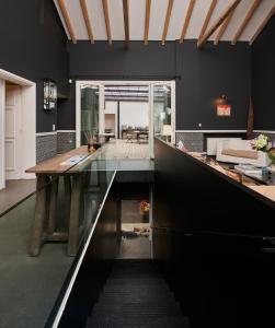 马科普隆瓦拉巴乡间民宿的一间用餐室,配有黑色的墙壁和玻璃桌