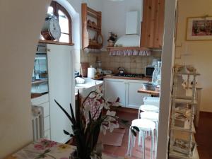 比萨Casale Cisanello的一间小厨房,配有白色橱柜和白色凳子