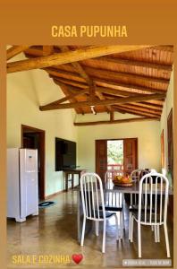 佩德拉阿祖尔Sitio dos Palmitos - Casa Pupunha的厨房配有桌椅和白色冰箱。