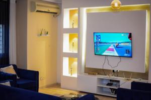 杜阿拉Appartement Cosy 3 bonapriso的客厅设有窗户,墙上配有电视。