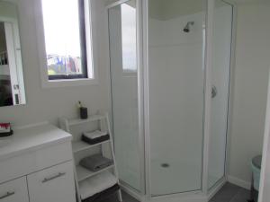 WaiauThe Bunkhouse的带淋浴和镜子的白色浴室