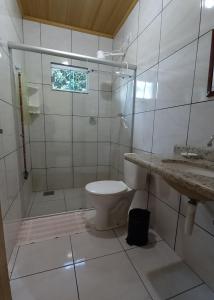 戈亚斯州上帕莱索POUSADA CANTO DOS PÁSSAROS的浴室配有卫生间、淋浴和盥洗盆。