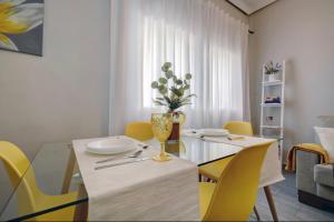 隆达13 Avenida Andalucía的一间带桌子和黄色椅子的用餐室