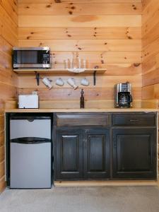 米勒斯堡Farmhouse Suites by Amish Country Lodging的厨房配有带冰箱和微波炉的柜台。