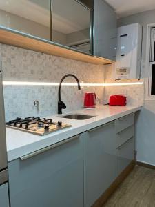 罗萨里奥Departamento Fabuloso的白色的厨房设有水槽和炉灶。