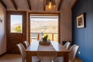 圣马丁德洛斯Oliver Mountain Home Blue的一间带桌椅和窗户的用餐室