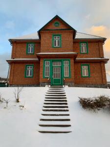 HraběšiceChata Klášter的雪中带绿门的房子