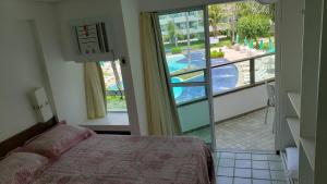 嘎林海斯港Ancorar Resort Vista Mar Flat 6103的一间卧室配有一张床,享有游泳池的景色