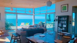 Waitoitoi180° seaviews, superior coastal cottage的客厅配有沙发和桌子