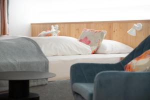 奥伊根多夫Santner, Hotel的一间卧室配有带白色床单和枕头的床。