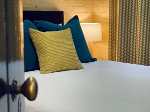 滕特菲尔德绍普奇颇斯夸特斯公寓的一张带蓝色和黄色枕头的床和一盏灯