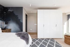 开普敦Always-Power Trendy De Waterkant Loft的卧室配有白色床和灰色墙