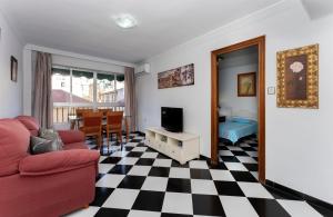 马拉加Malaga downtown and beach apartment的客厅配有红色沙发和电视