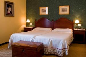 阿瓜尔达圣贝尼托修道院酒店的一间卧室配有两张床、两张桌子和两盏灯。