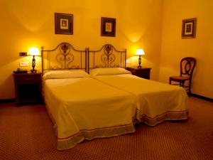 阿瓜尔达圣贝尼托修道院酒店的一间卧室配有一张带两盏灯的大型白色床。