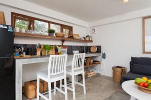 涛岛海角鲨鱼别墅的厨房配有两把白色椅子和台面