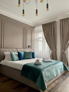 利沃夫Von Cruss apartments in Lviv的一间卧室配有一张带蓝色枕头的大床