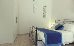 马鲁焦B&B Le Vele的一间卧室配有一张带蓝色毯子的床
