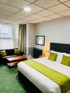 伊尔弗勒科姆Palm Court B&B的酒店客房设有一张大床和一张沙发。