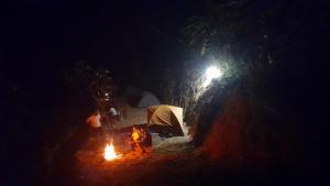 马迪凯里Nature river camp的站在 ⁇ 火旁的人