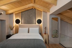 约阿尼纳Hypnos Cozy Living的卧室配有一张白色大床和木制天花板