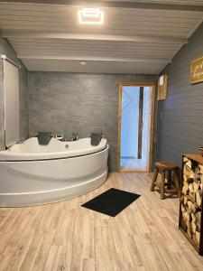 莱森路乐榛子度假屋的带浴缸的大浴室和木地板