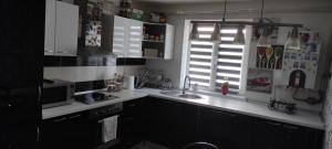 Vulcankys home的厨房配有白色的柜台、窗户和水槽。