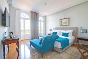 辛特拉Villa Bela Vista的一间卧室配有一张大床和一张蓝色椅子