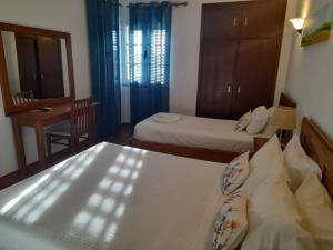 雷根古什-迪蒙萨拉什Terras de Monsaraz的一间卧室配有两张床、一张桌子和一面镜子