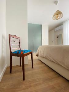 博蒂卡什Casa Sousa - 3rd generation (Apart.2)的坐在床边的卧室里的椅子