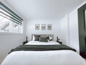 蒙特朗布朗Complexe LIVTremblant by Gestion ELITE - LIV5的卧室配有一张大白色床和窗户