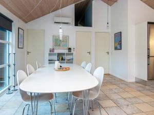 Øksenmølle8 person holiday home in Ebeltoft的白色的用餐室配有白色的桌椅