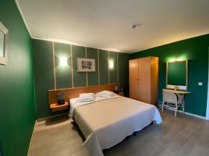 Tielt登霍克酒店的一间卧室设有一张床和绿色的墙壁