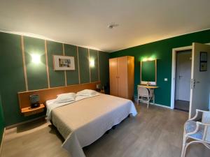 Tielt登霍克酒店的一间卧室设有一张床和绿色的墙壁