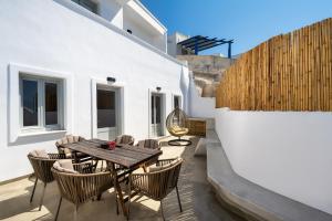 皮尔戈斯Astivi Santorini Apartments的庭院配有木桌和椅子