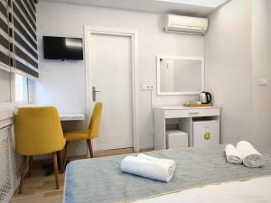 伊斯坦布尔Olen Altunizade Hotel的一间卧室配有一张带黄椅的床和一张书桌
