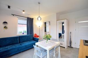 罗威Morski Zakątek Apartamenty的客厅配有蓝色的沙发和桌子